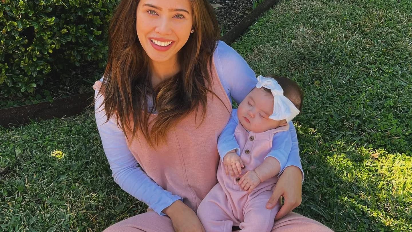 April sitting on the grass with her daughter
